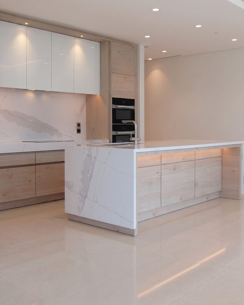 Residence kitchen with a veined white waterfall island and matching splashback supplied by Mina Surface, Four Seasons Private Residences, Bahrain Bay
