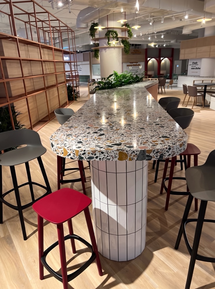 Communal dining counter in multicolour aggregate terrazzo at Picnic Square, Times Square Center, Dubai — supplied by Mina Surface
