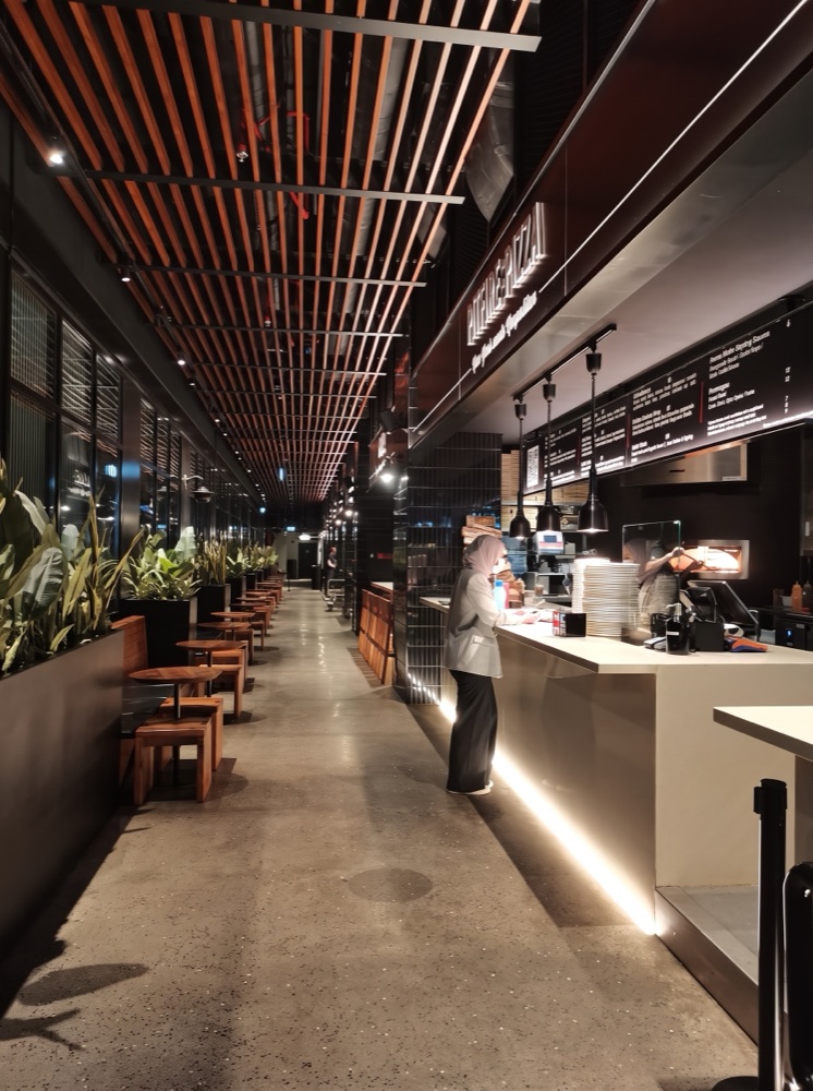 Polished aggregate concourse flooring through the food hall at Time Out Market, Dubai — supplied by Mina Surface